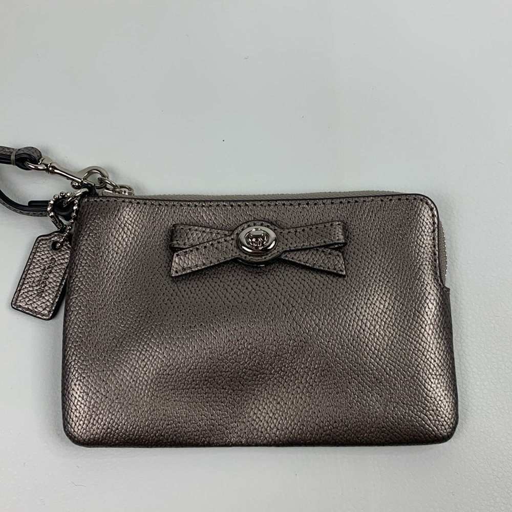 Coach Leather metallic Silver wristlet with bow Zip close Charm tag Lined pocket